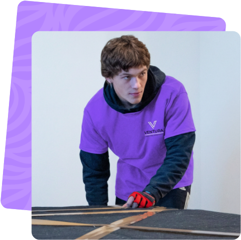 Ventura mover taping a box beside the company moving truck